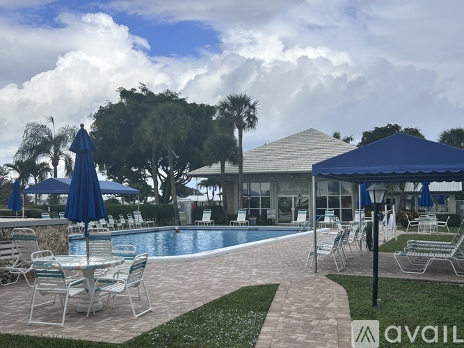 A pool area with chairs and umbrellas is available for use.