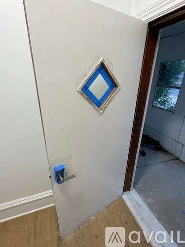 A white wall with a blue square tile in the middle.