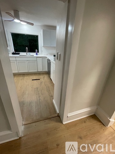 A kitchen with white cabinets and a window.
