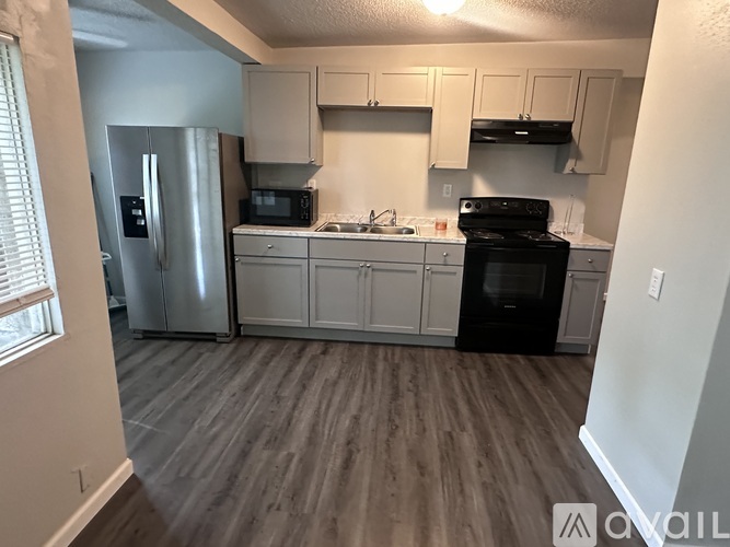 A kitchen with a refrigerator, microwave, oven, and stove.