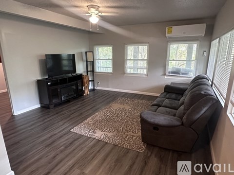 A living room with a brown leather couch and a flat screen TV.