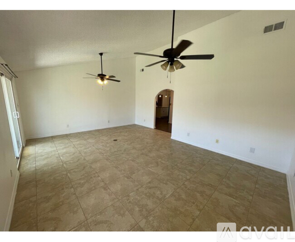 A room with a tiled floor and two ceiling fans.