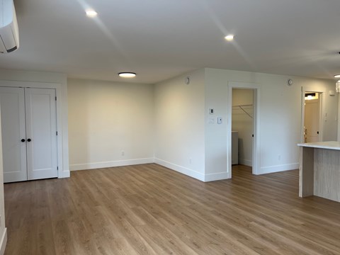 A room with wooden flooring and white walls.