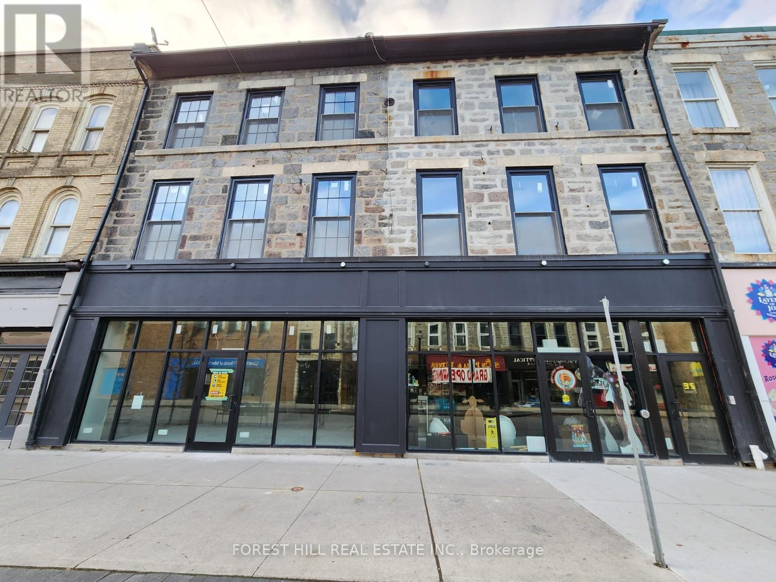 A building with a black facade and a sign that says "FOREST HILL REAL ESTATE V.C." in front of it.