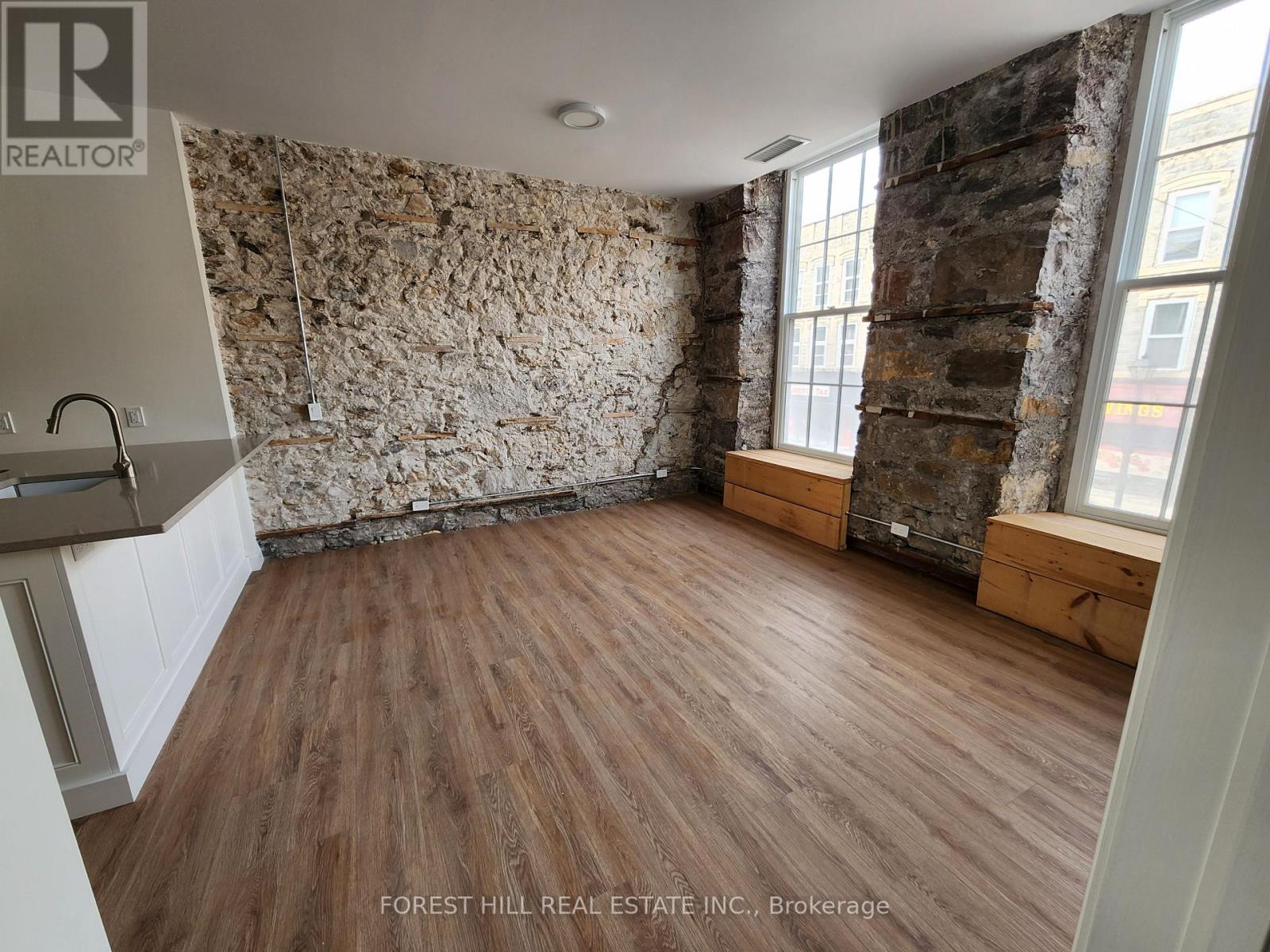 A room with wooden floors and a stone wall.