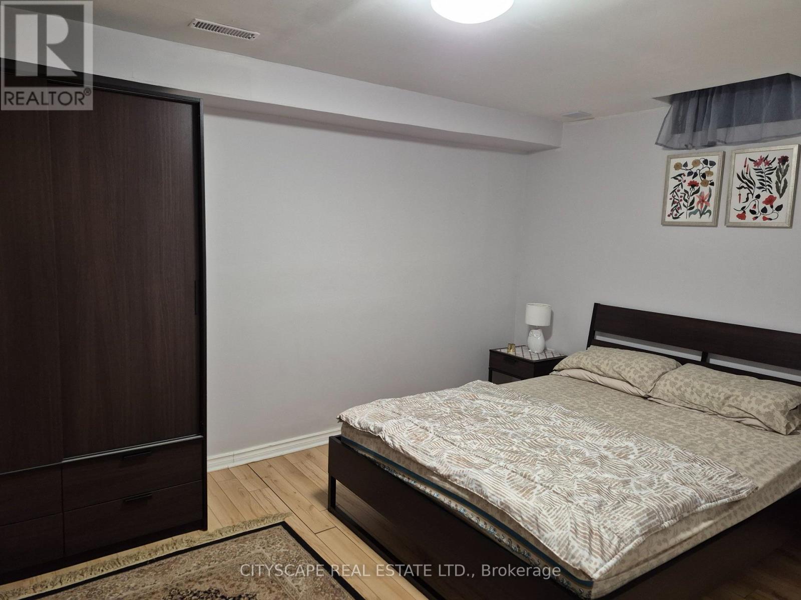 A bedroom with a bed, nightstand, and wardrobe.