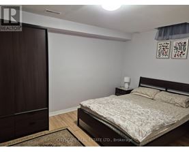 A bedroom with a bed, nightstand, and wardrobe.