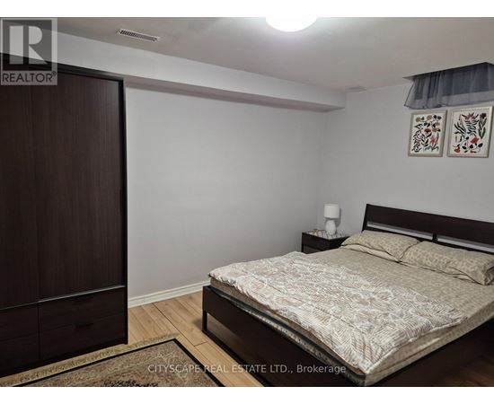 A bedroom with a bed, nightstand, and wardrobe.