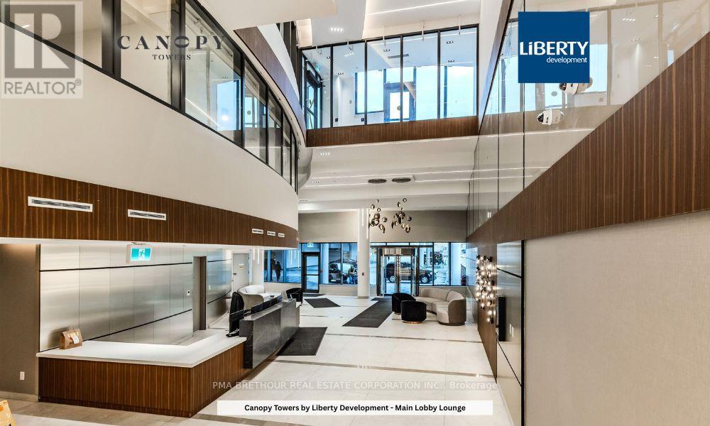 A lobby lounge with a glass wall and a sign that says "Canopy Towers by Liberty Development".
