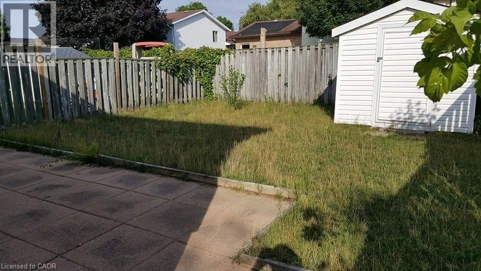 A backyard with a wooden fence and a shed.