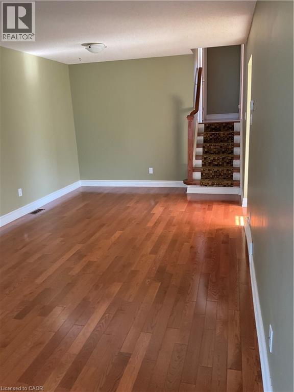 A room with wooden flooring and a staircase.