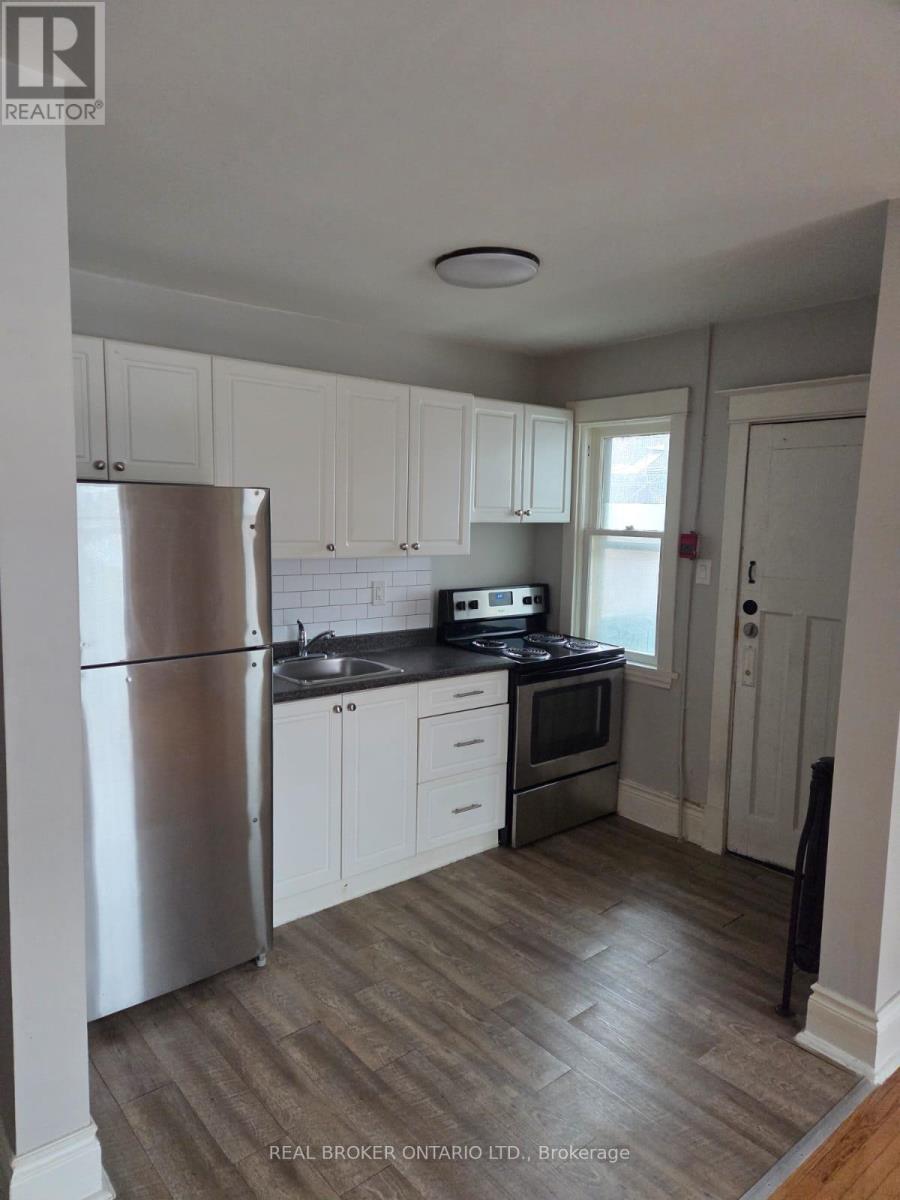 A kitchen with white cabinets and a stainless steel refrigerator.