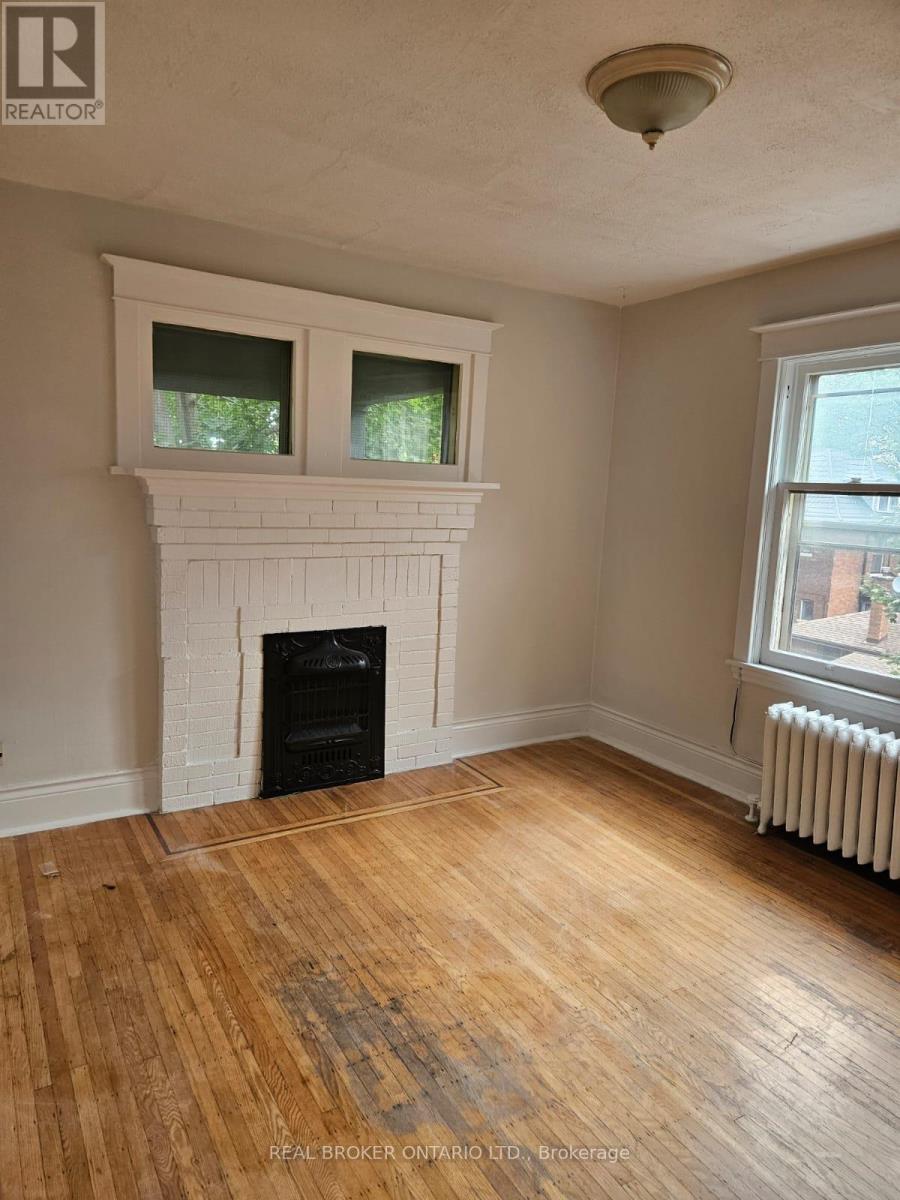 A room with a fireplace and wood flooring.