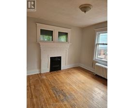 A room with a fireplace and wood flooring.