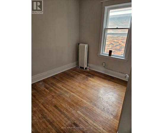 A room with a window and a radiator on the wall.