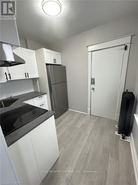 A kitchen with white cabinets and a black countertop.