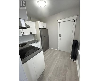 A kitchen with white cabinets and a black countertop.