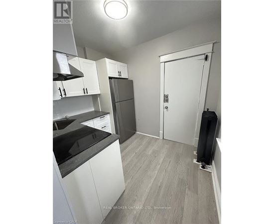 A kitchen with white cabinets and a black countertop.