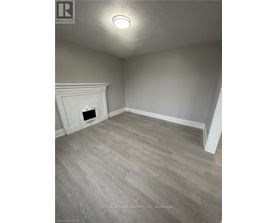A room with a fireplace and wood flooring.