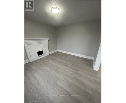 A room with a fireplace and wood flooring.