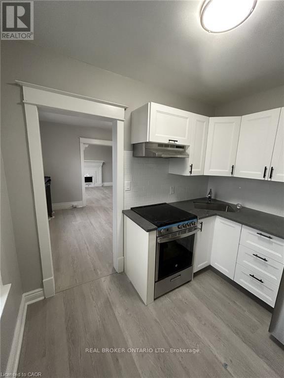 A kitchen with white cabinets and a black countertop.