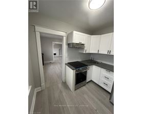 A kitchen with white cabinets and a black countertop.