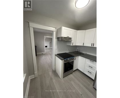 A kitchen with white cabinets and a black countertop.