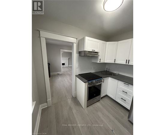 A kitchen with white cabinets and a black countertop.