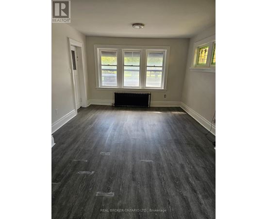 A room with wood flooring and a window.