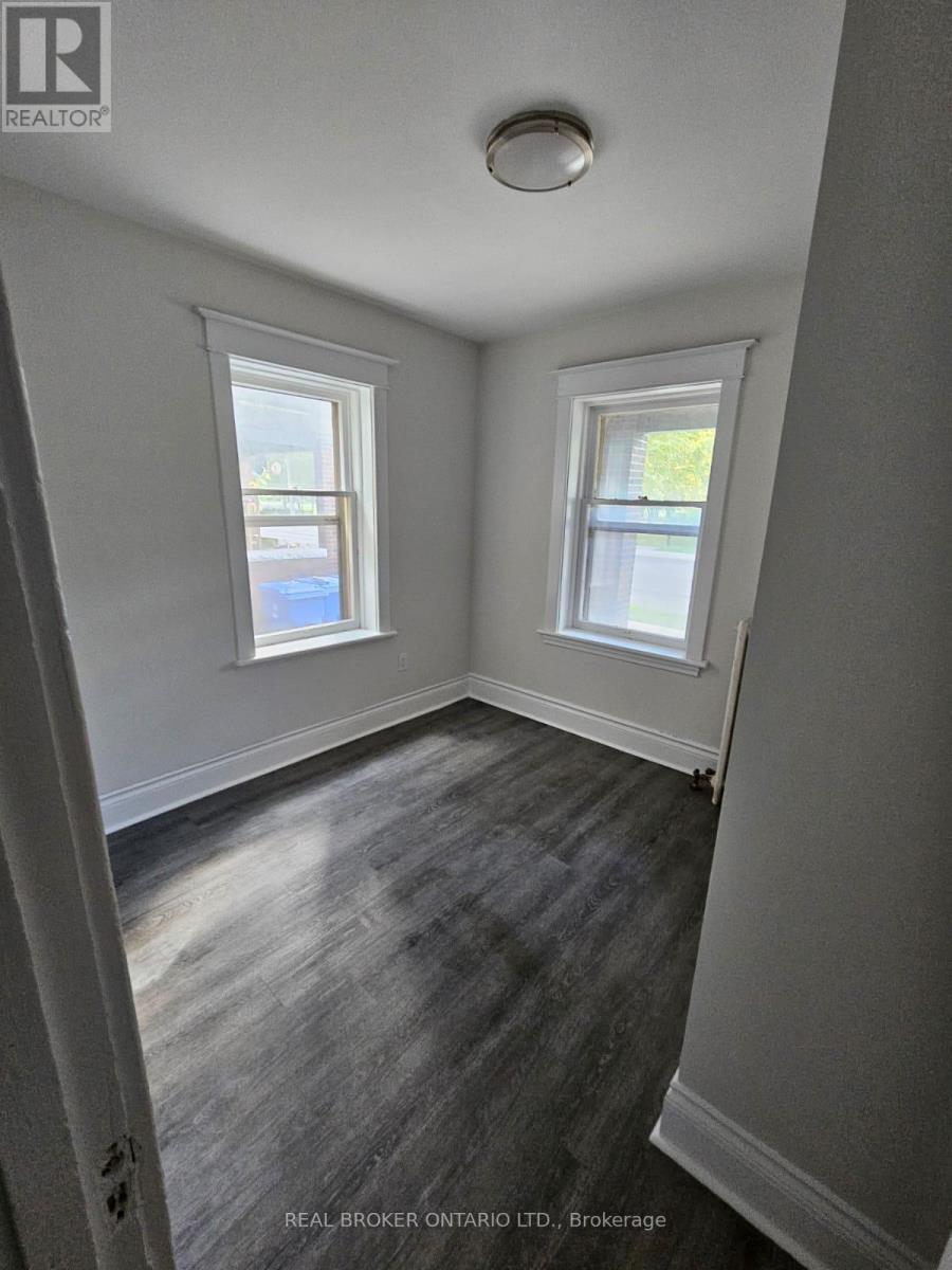 A room with two windows and a wooden floor.