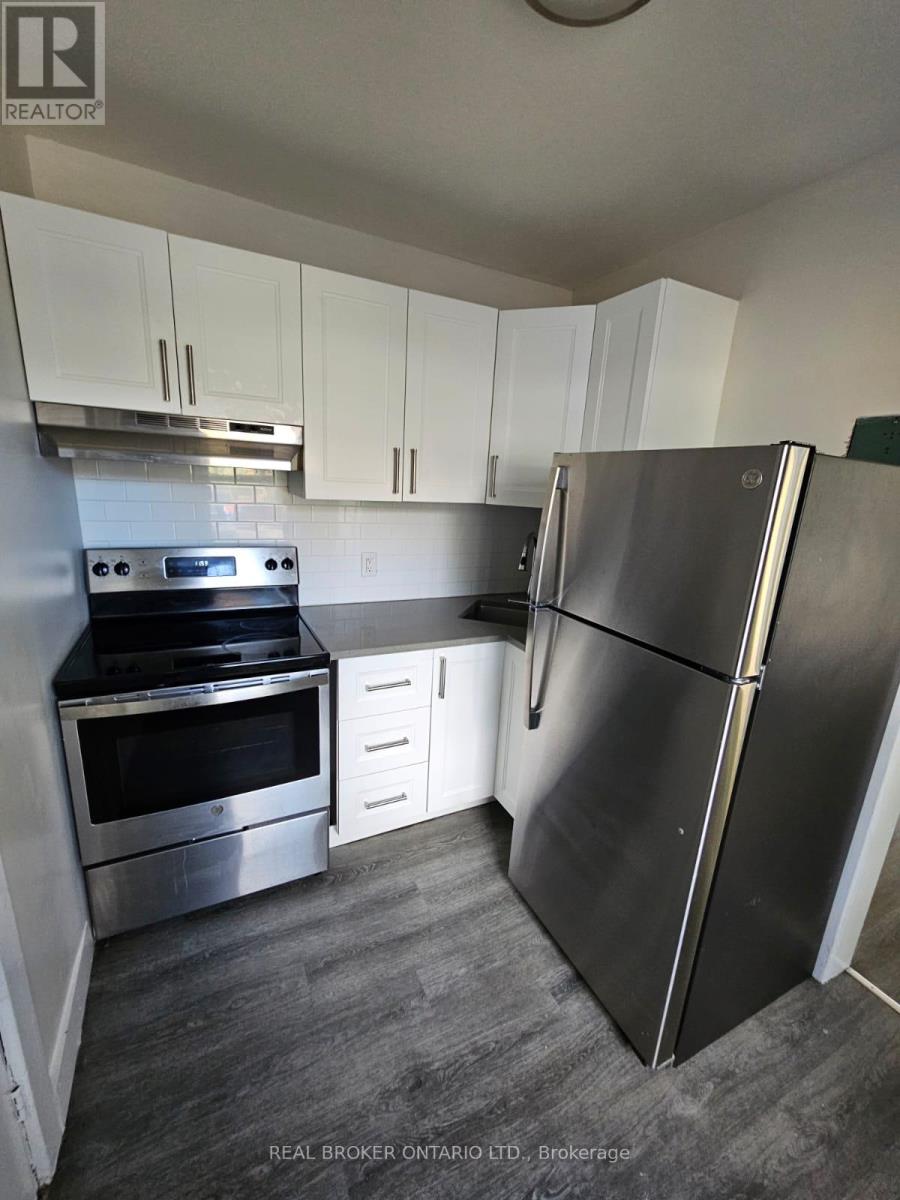 A kitchen with a stainless steel refrigerator, oven, and microwave.