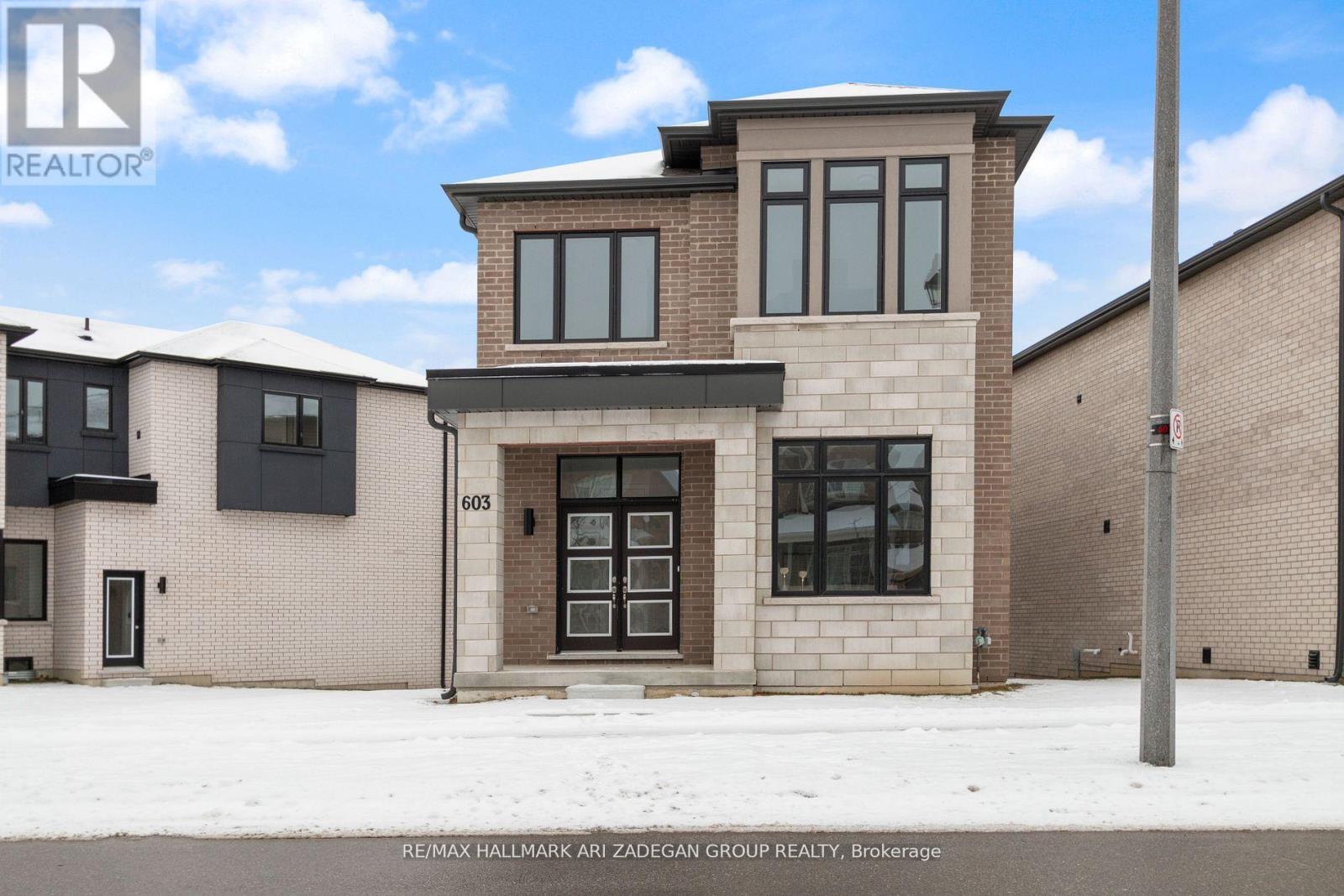 A modern house with a brick facade is for sale.