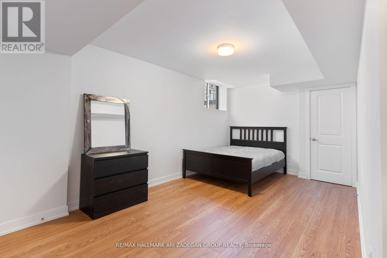 A bedroom with a bed, dresser, and mirror.