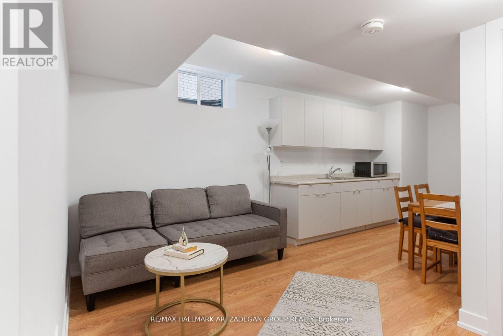 A living room with a grey couch and a small table with a book on it.