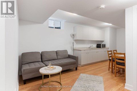 A living room with a grey couch and a small table with a book on it.
