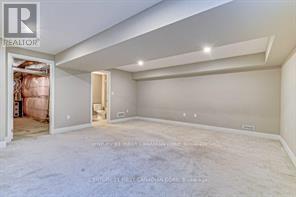 A spacious empty room with a doorway leading to another room.