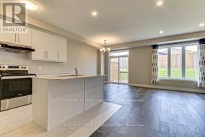 A modern kitchen with white cabinets and a black stove top oven.