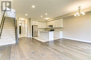 A spacious living room with a staircase leading to the upper floor.