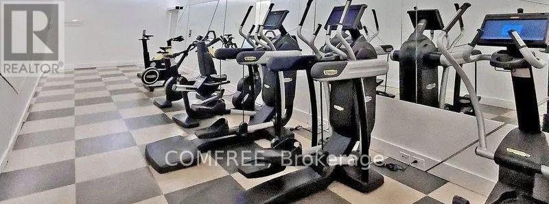 A row of exercise bikes are lined up in a gym.