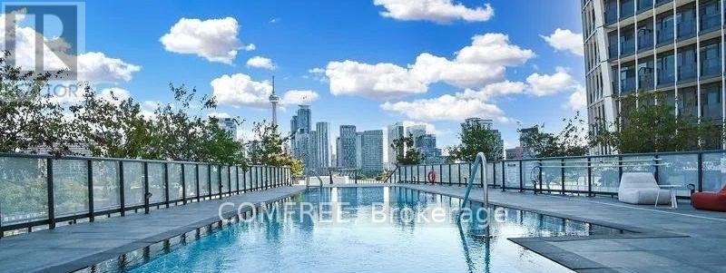 A pool on a balcony with a city skyline in the background.
