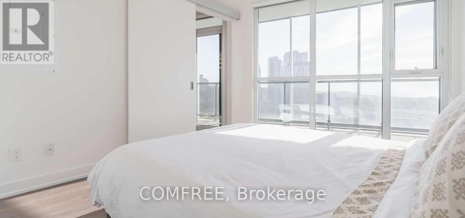 A bedroom with a large bed and a view of the city.