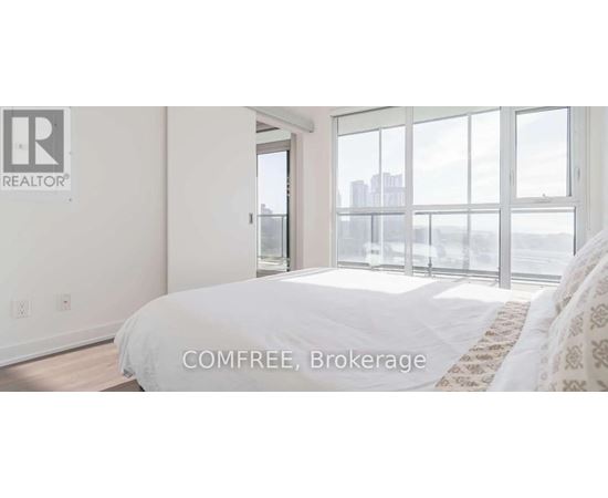 A bedroom with a large bed and a view of the city.
