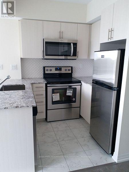 A kitchen with a stove, oven, microwave, and refrigerator.