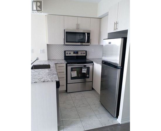 A kitchen with a stove, oven, microwave, and refrigerator.