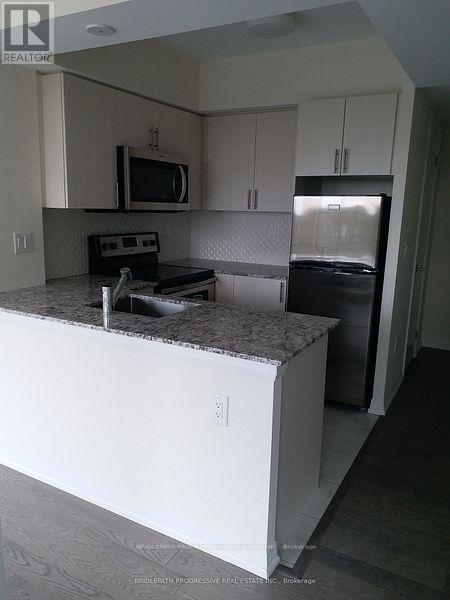 A kitchen with white cabinets and a granite countertop.