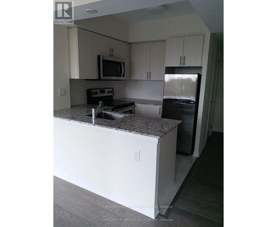 A kitchen with white cabinets and a granite countertop.