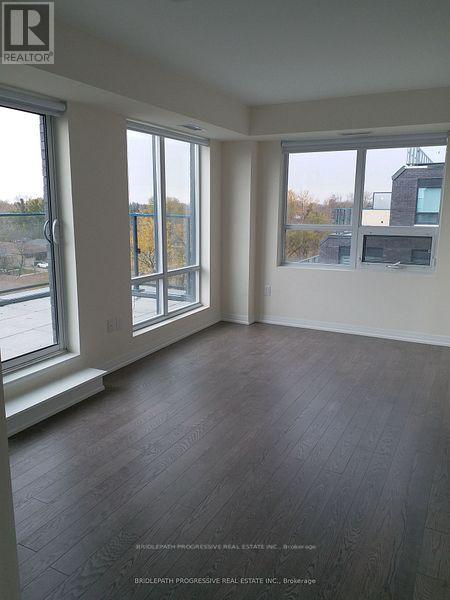 A room with a large window and a wooden floor.
