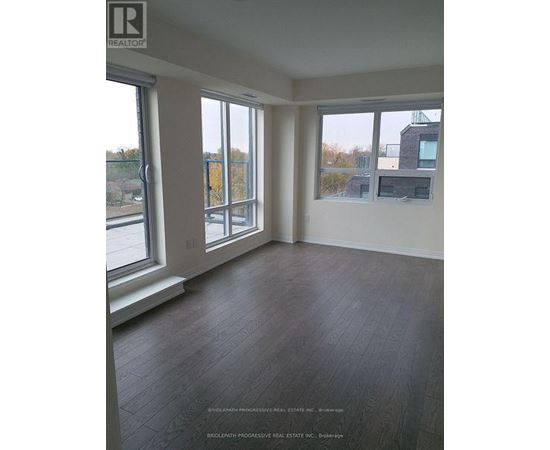 A room with a large window and a wooden floor.