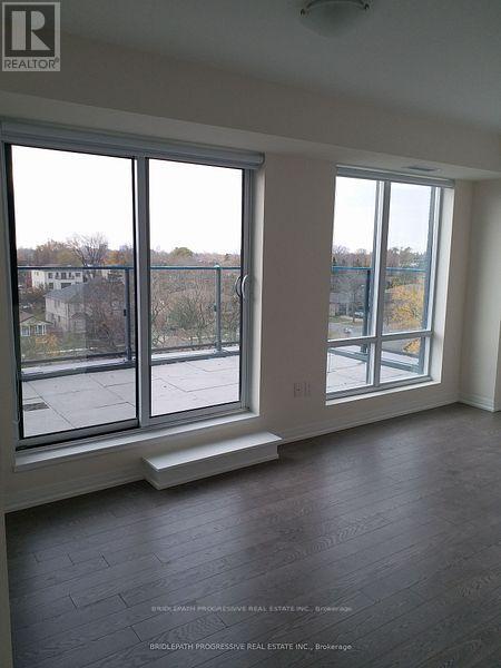 A large empty room with a view of the outside through the windows.