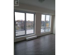 A large empty room with a view of the outside through the windows.
